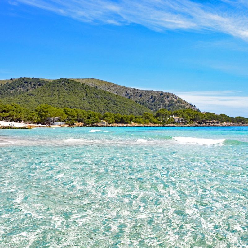 Kristallklarer Sandstrand Cala Agulla an einem sonnigen Tag